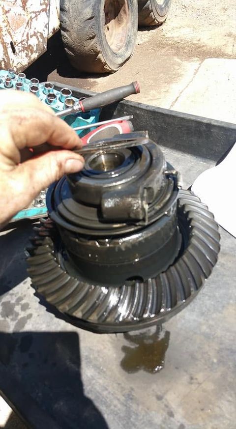 Hand holding a differential carrier with bearing and ring gear during a gear setup